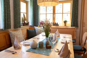 巴德伊舍的住宿－Gasthof Rettenbachalm，餐桌上摆放着玻璃杯和鲜花