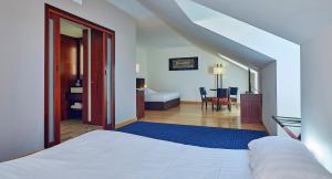 - une chambre avec un lit blanc et une chambre avec une table dans l'établissement Le Mauritia Hotel et Spa, à Pornic