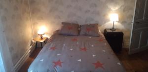 Un dormitorio con una cama con estrellas. en Le Mas Maison de village en Vabre