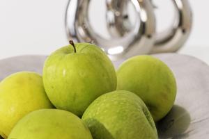 a pile of green apples on a plate with a juicer at Central Hotel in Villingen-Schwenningen