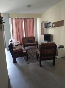 a living room with two chairs and a television at Apartamento T2 em Sal Rei - Boavista in Sal Rei