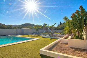 un patio trasero con piscina, plantas y sol en Casa del Sol, en Peñíscola