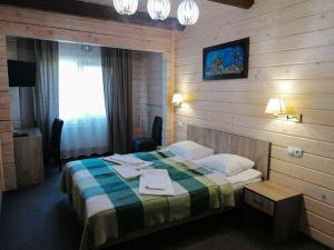 a hotel room with a bed with a plaid blanket at Шале На бе́резі in Kvasy