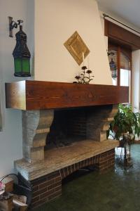 - un salon doté d'une cheminée en briques et d'un manteau en bois dans l'établissement Al Picchio Verde A.P.S., à Cunardo