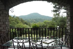 d'une table et de chaises sur un balcon avec des montagnes en arrière-plan. dans l'établissement Al Picchio Verde A.P.S., à Cunardo