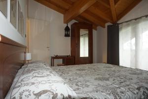 a bedroom with a bed and a wooden ceiling at Al Picchio Verde A.P.S. in Cunardo