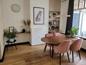 a dining room with a table and pink chairs at Characteristic ground floor apartment with box bed in Groningen