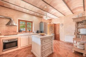 a large kitchen with a sink and a stove at Finca Santigor in Cala Ferrera