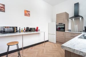 a kitchen with a white refrigerator and a counter at Vibrant Funkily Decorated 2 Bedroom 4 Beds Central Location in Hull