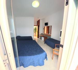 a bedroom with a blue bed and a living room at Hotel Klein Wien in Piano di Sorrento