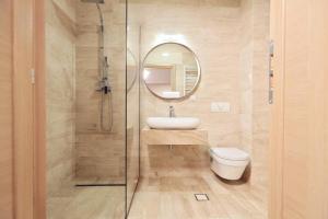 a bathroom with a sink and a toilet and a mirror at Living In Aparthotel in Oradea +73 photos