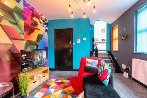 a living room with a tv and a colorful wall at Vibrant Funkily Decorated 2 Bedroom 4 Beds Central Location in Hull