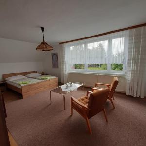 1 dormitorio con cama, mesa y sofá en Pension Kristýna en Kašperské Hory