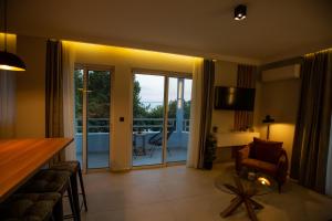 ein Wohnzimmer mit Blick auf einen Balkon in der Unterkunft Vallia Suites - Luxury Suite in Nafpaktos