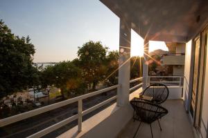 einen Balkon mit 2 Stühlen und Stadtblick in der Unterkunft Vallia Suites - Luxury Suite in Nafpaktos