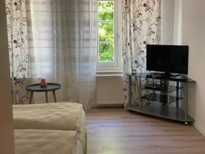 a room with a television on a table in front of a window at Rezas Restaurant Gästehaus in Oberbillig
