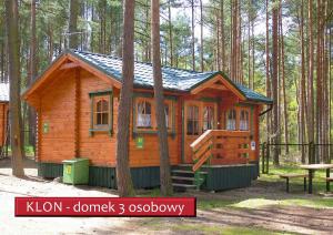 eine kleine Holzhütte im Wald mit einem Picknicktisch in der Unterkunft Ośrodek Wypoczynkowy Kormoran Niesulice in Niesulice