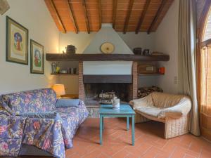 ein Wohnzimmer mit einem Sofa und einem Kamin in der Unterkunft Holiday Home Il Poderino by Interhome in Chiocchio