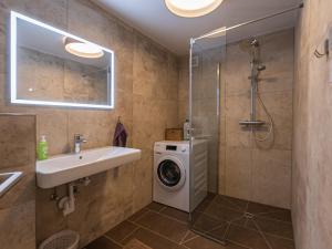 een badkamer met een wasmachine en een wastafel bij Holiday Home Pfisterer - BRG150 by Interhome in Taxenbach
