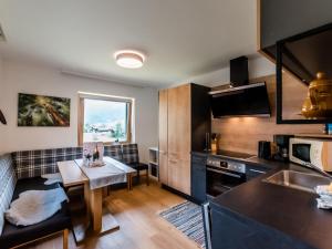 małą kuchnię ze stołem i kanapą w obiekcie Holiday Home Pfisterer by Interhome w mieście Taxenbach