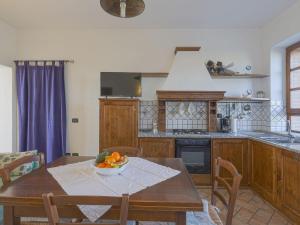 a kitchen with a table with a bowl of fruit on it at Holiday Home Cignanbianco - Alba by Interhome in Castellina in Chianti
