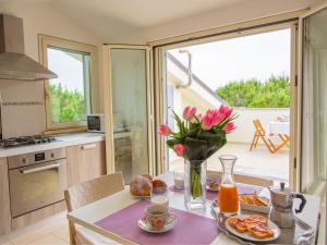 kuchnia ze stołem z wazonem kwiatów w obiekcie Holiday Home Michela-2 by Interhome w mieście Pineto