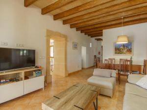 ein Wohnzimmer mit einem Sofa, einem TV und einem Tisch in der Unterkunft Holiday Home Can Marines des cami des carro by Interhome in S'Horta
