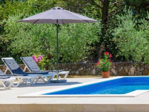 - un parasol et des chaises à côté de la piscine dans l'établissement Holiday Home Carla - LBN429 by Interhome, à Labin