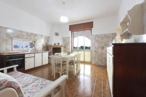 Una cocina con una mesa y un comedor. en Villetta Goccia D'oro, en Torre Suda 10 fotos más