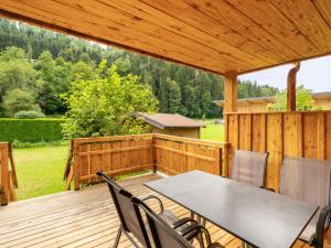 a patio with a table and chairs on a wooden deck at Chalet Bergerlodge by Interhome in Schladming
