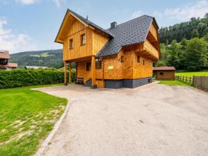 een houten huis met een gambrel dak op een oprit bij Chalet Bergerlodge by Interhome in Schladming