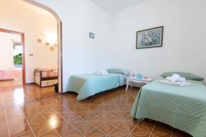 una habitación con dos camas y un espejo en Villetta Goccia D'oro, en Torre Suda