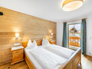 een slaapkamer met een groot wit bed met een houten wand bij Chalet Bergerlodge by Interhome in Schladming