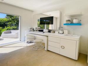 eine weiße Küche mit einem Waschbecken und einem Spiegel in der Unterkunft Holiday Home House Boat Small by Interhome in San Teodoro
