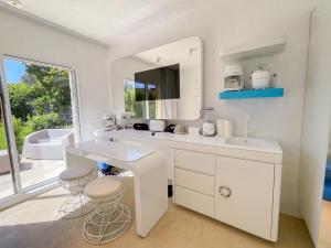 ein weißes Badezimmer mit einem Waschbecken und einem Spiegel in der Unterkunft Holiday Home House Boat Small by Interhome in San Teodoro