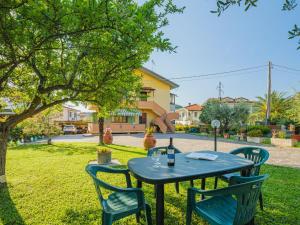 a blue table and chairs under a tree in a yard at Apartment Renzo by Interhome in Quiesa