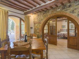 ein Esszimmer mit einem Holztisch und einem Torbogen in der Unterkunft Apartment Cellole - La Stalla by Interhome in Castellina in Chianti