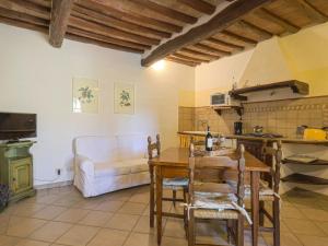 eine Küche und ein Wohnzimmer mit einem Tisch und einem Sofa in der Unterkunft Apartment Cellole - La Stalla by Interhome in Castellina in Chianti