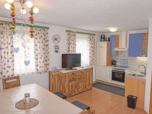 ein Wohnzimmer mit einem Tisch und einer Küche in der Unterkunft Apartment Christina by Interhome in Pettneu am Arlberg