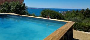a swimming pool with a view of the water at Peaceful Cherry Place in Portorož