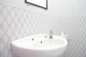 une salle de bains avec un lavabo blanc et un miroir dans l'établissement ReDdoorz At Mahameru Residence Yogyakarta, à Yogyakarta 46 autres photos