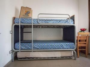 two bunk beds in a room with a table at Holiday Home Miramare-3 by Interhome in Antignano +26 photos