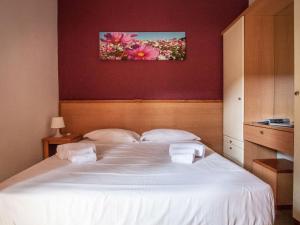 um quarto com uma cama branca com duas toalhas em Holiday Home Miramare-3 by Interhome em Antignano