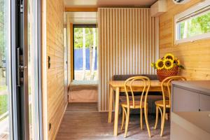 a tiny house with a dining room with a table and chairs at Arche Siedlisko Augustynka 59 in Nurzec