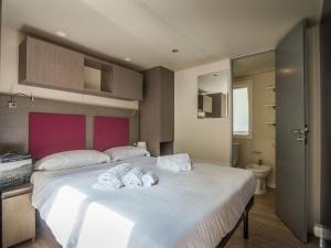 a bedroom with a large white bed with towels on it at Holiday Home Miramare-1 by Interhome in Antignano
