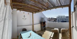 einen Balkon mit einem Tisch und einem Holzofen in der Unterkunft AmuraHouse. Private terrace BBQ. Centric and cosy. in Cotillo