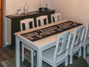 Holiday Home Kelokivakka d19 by Interhome في روكا: طاولة غرفة طعام مع أربعة كراسي وكاونتر