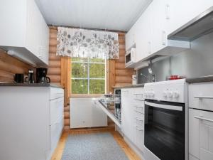 ルカにあるHoliday Home Kuontila by Interhomeの白いキャビネットと窓付きのキッチン