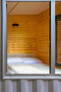 a glass walled bedroom with a bed inside of it at Arche Siedlisko Augustynka 59 