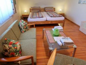 a living room with a couch and a bed at Holiday Home Roth by Interhome in Neuried +11 photos